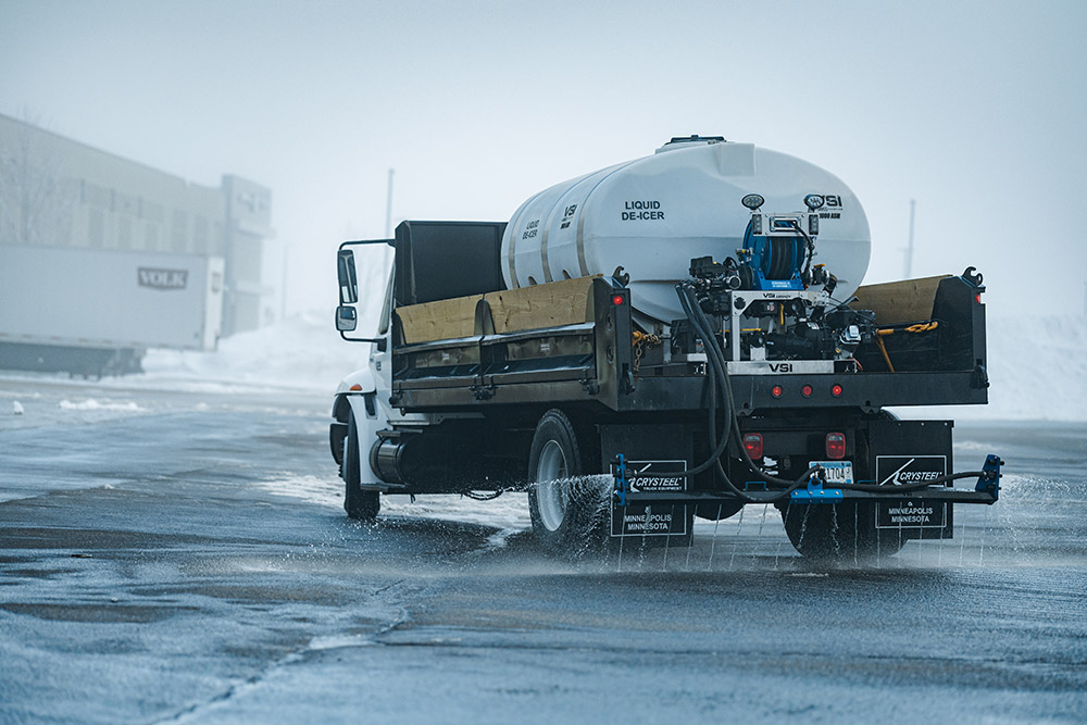 Truck equipped with liquid de-icer, spraying pavement.